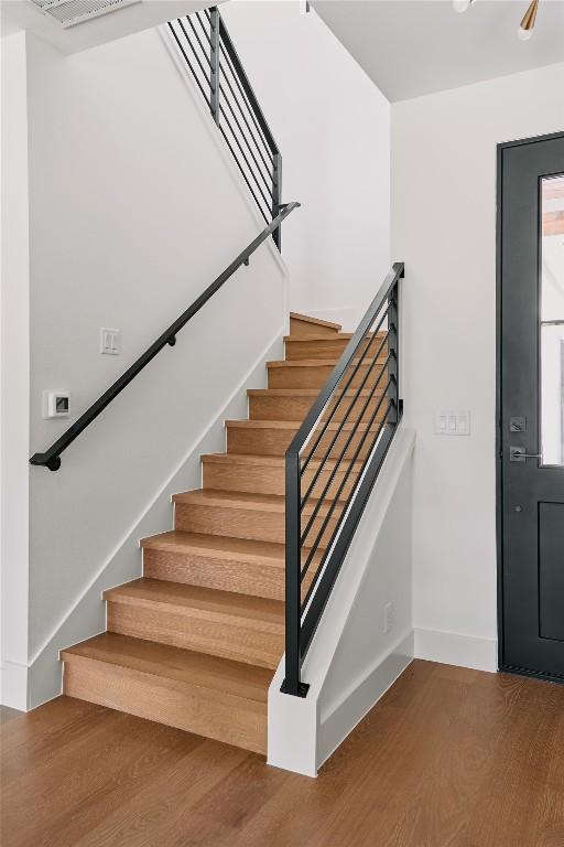 stairs featuring wood finished floors and baseboards