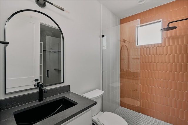 bathroom with tiled shower, toilet, and vanity
