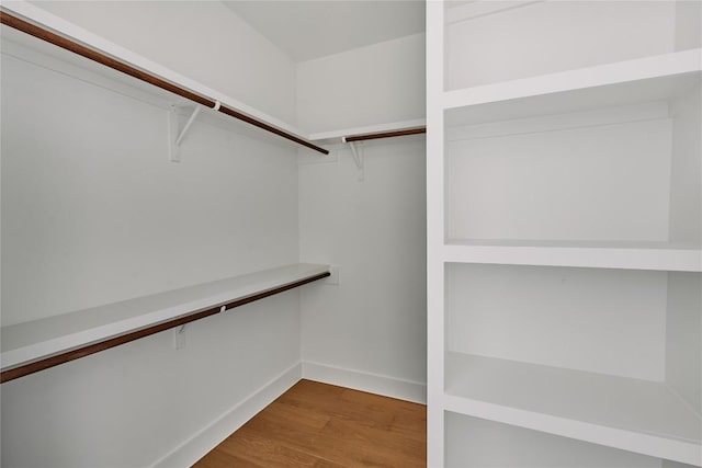 walk in closet with wood finished floors