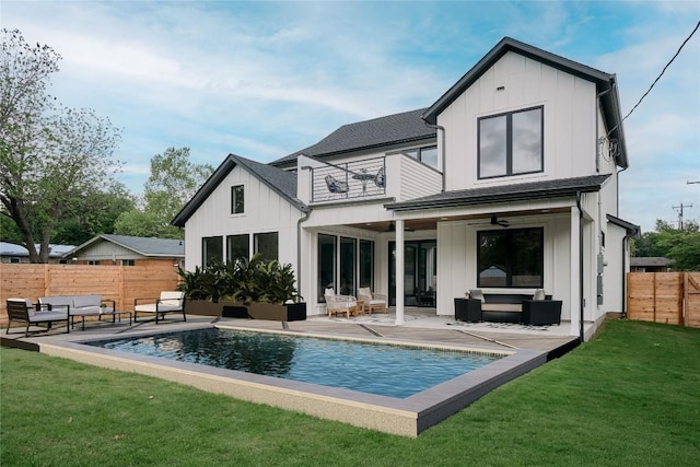 back of house with a balcony, an outdoor living space, board and batten siding, and a ceiling fan