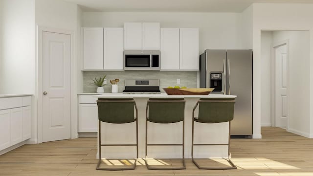 kitchen featuring appliances with stainless steel finishes, a center island, a breakfast bar, and white cabinetry