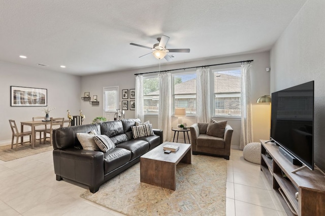 living room with a ceiling fan, light tile patterned floors, recessed lighting, and baseboards