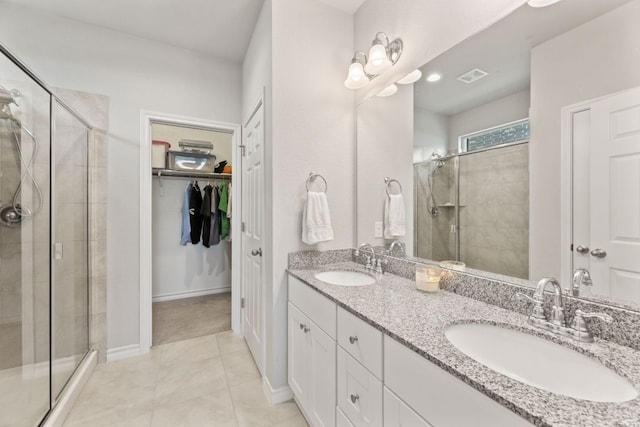 537 Appalachian Trl, Leander, TX 78641 - full bathroom with a stall shower, double vanity, a spacious closet, tile patterned flooring, and baseboards