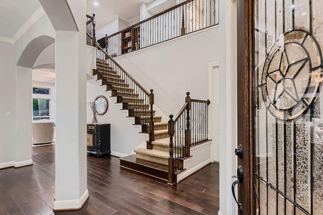 2516 Arion Cir, Austin, TX 78730 - foyer entrance featuring arched walkways, baseboards, crown molding, wood finished floors, and stairway
