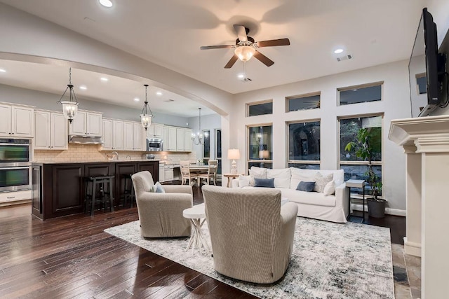 2516 Arion Cir, Austin, TX 78730 - living area with arched walkways, a ceiling fan, recessed lighting, dark wood-style flooring, and a chandelier