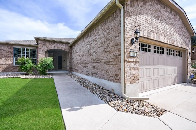 111 Bear Creek Ln, Georgetown, TX 78633 - view of side of home with an attached garage, brick siding, driveway, and a yard