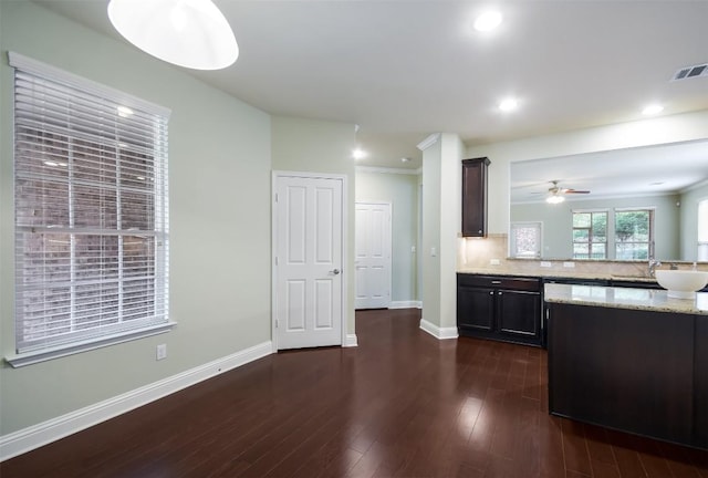 111 Bear Creek Ln, Georgetown, TX 78633 - kitchen with dark wood-style floors, baseboards, a peninsula, light stone countertops, and a sink