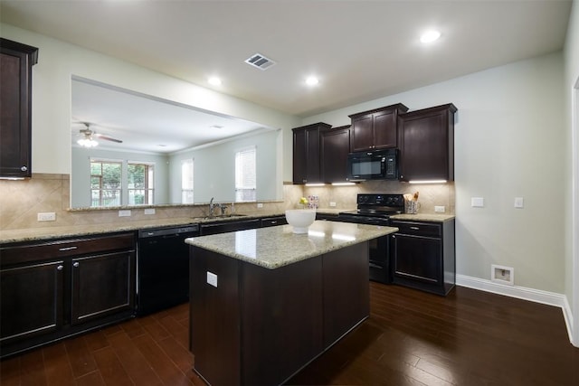 111 Bear Creek Ln, Georgetown, TX 78633 - kitchen with black appliances, a sink, dark wood-style floors, a center island, and light stone countertops