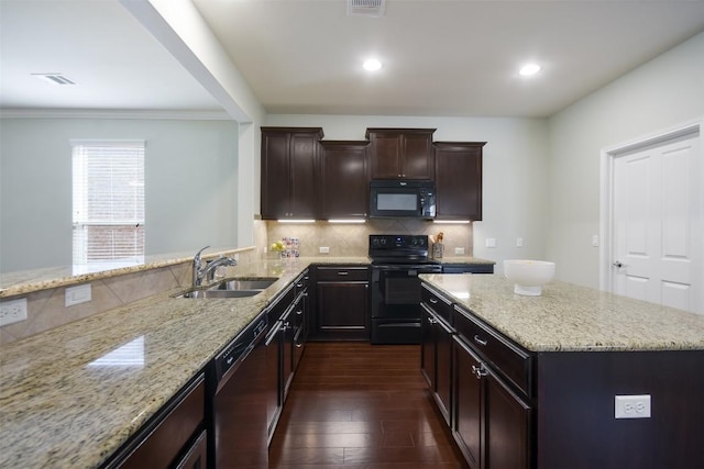 111 Bear Creek Ln, Georgetown, TX 78633 - kitchen with black appliances, light stone countertops, dark wood-type flooring, tasteful backsplash, and ornamental molding
