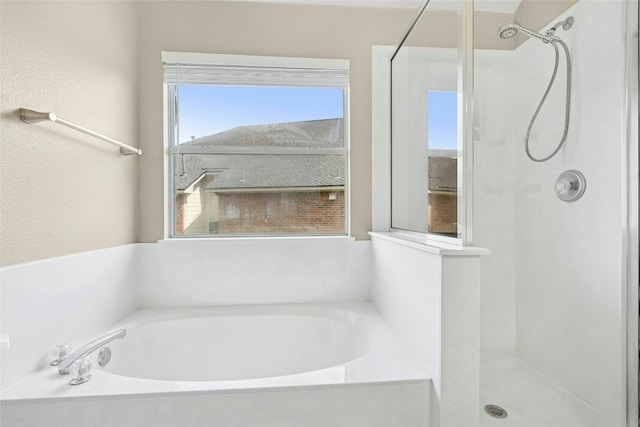 bathroom featuring a stall shower and a garden tub