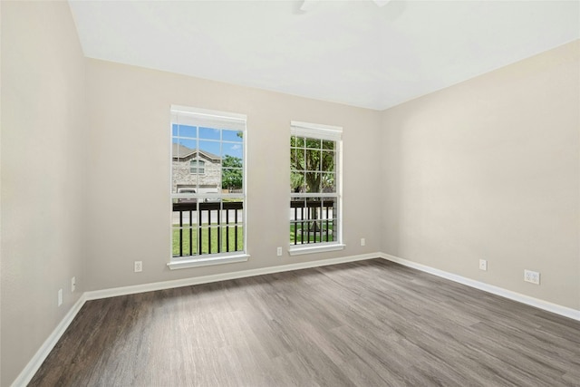 spare room with wood finished floors and baseboards