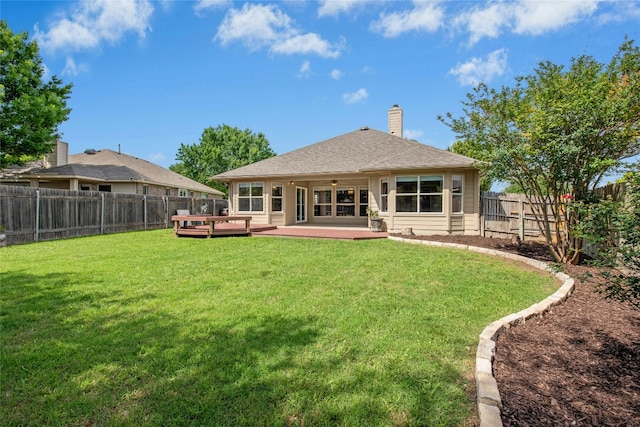 back of house with a deck, a chimney, a ceiling fan, and a shingled roof
