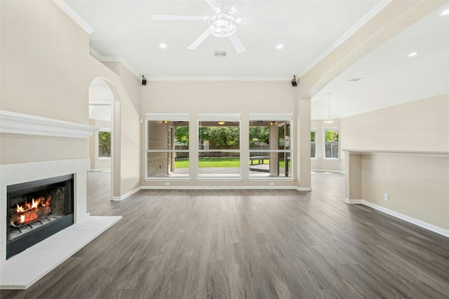 unfurnished living room with a fireplace, ornamental molding, baseboards, wood finished floors, and healthy amount of natural light