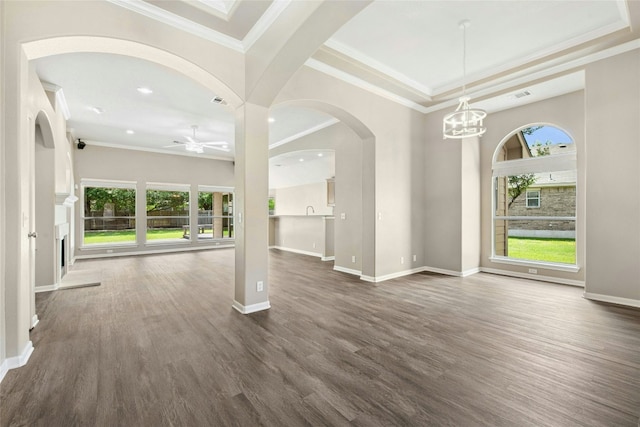 empty room with plenty of natural light, dark wood finished floors, a chandelier, ornamental molding, and recessed lighting