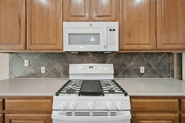 kitchen with white appliances, tasteful backsplash, and light countertops