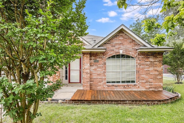 view of front of home featuring brick siding and a front yard