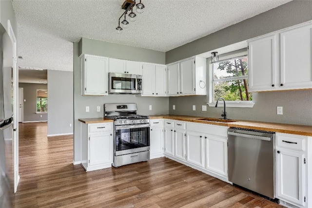 3109 Blazing Star Trl, Cedar Park, TX 78613 - kitchen with appliances with stainless steel finishes, wooden counters, a textured ceiling, dark wood-style flooring, and plenty of natural light