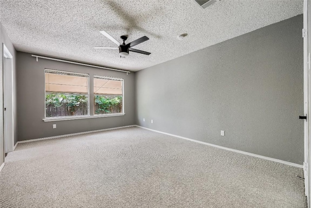 carpeted empty room featuring ceiling fan, a textured ceiling, a textured wall, and baseboards