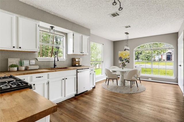 kitchen featuring dishwasher, a sink, butcher block countertops, dark wood finished floors, and white cabinetry