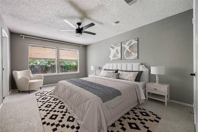 bedroom featuring carpet, a textured ceiling, ceiling fan, and baseboards