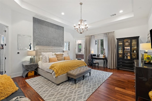 bedroom featuring a chandelier, wood finished floors, a tray ceiling, recessed lighting, and baseboards