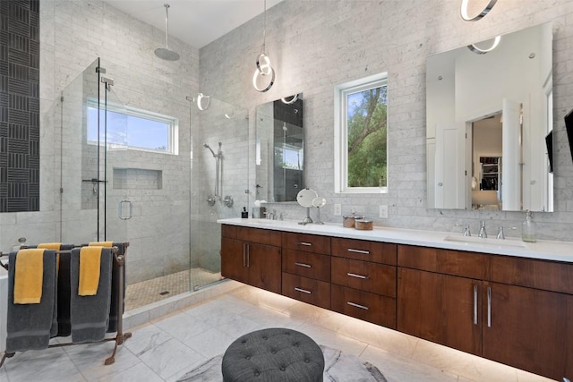 908 Cypress Grove Dr, Austin, TX 78732 - full bathroom featuring double vanity, a shower stall, plenty of natural light, tile walls, and marble finish floors