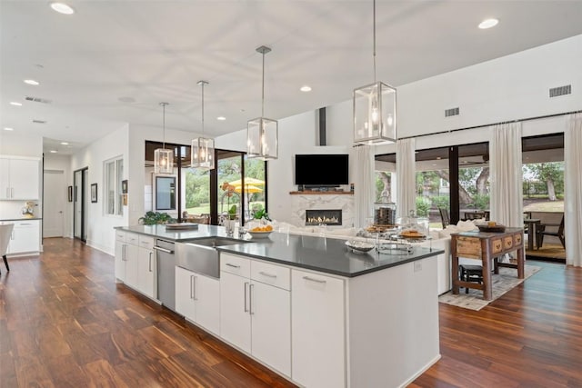 908 Cypress Grove Dr, Austin, TX 78732 - kitchen featuring open floor plan, dark wood-style flooring, dark countertops, a large island with sink, and recessed lighting
