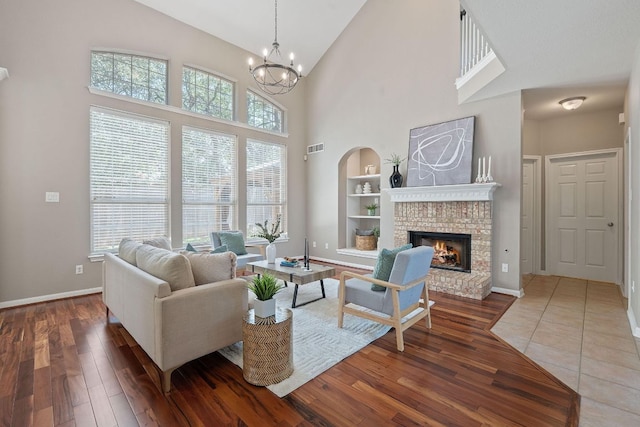 9013 Lantana Way, Austin, TX 78749 - living area with high vaulted ceiling, wood-type flooring, a brick fireplace, built in features, and a chandelier