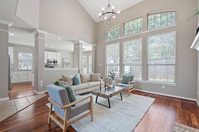 9013 Lantana Way, Austin, TX 78749 - living area featuring decorative columns, healthy amount of natural light, hardwood / wood-style flooring, high vaulted ceiling, and baseboards