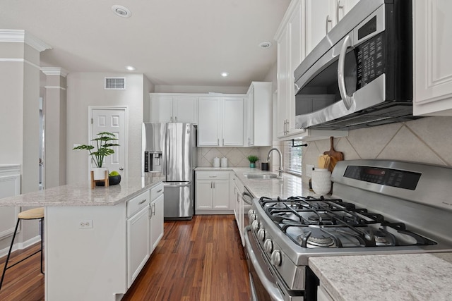 9013 Lantana Way, Austin, TX 78749 - kitchen with appliances with stainless steel finishes, a sink, dark wood finished floors, white cabinetry, and recessed lighting