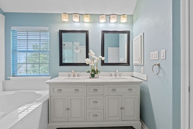 9013 Lantana Way, Austin, TX 78749 - bathroom featuring a garden tub, a textured wall, and double vanity