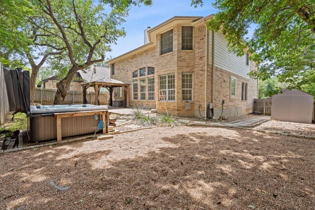 9013 Lantana Way, Austin, TX 78749 - rear view of property with a hot tub, a gazebo, a fenced backyard, and brick siding