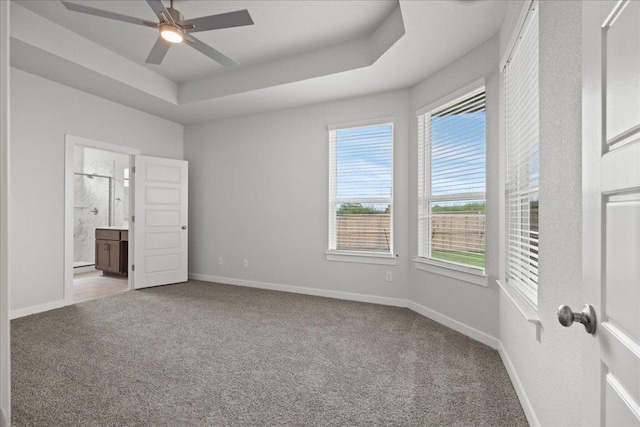 115 Paul Pena Dr, San Marcos, TX 78666 - unfurnished bedroom with carpet floors, baseboards, ensuite bath, and a tray ceiling