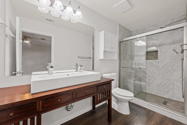 7516 Marble Crest Dr, Austin, TX 78747 - bathroom featuring a shower stall, toilet, wood finished floors, ceiling fan, and vanity