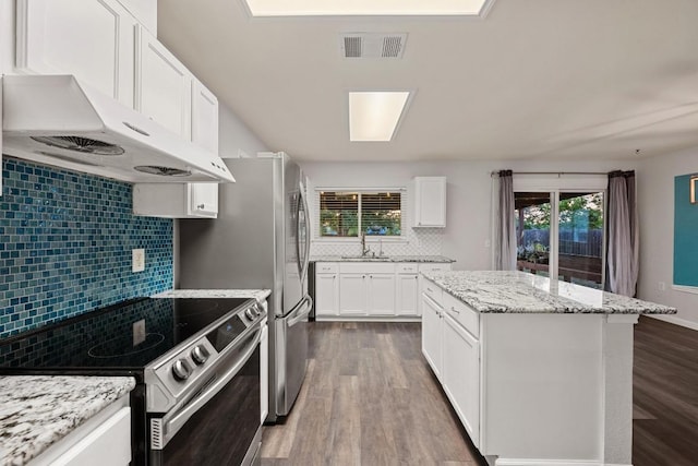 7516 Marble Crest Dr, Austin, TX 78747 - kitchen with electric stove, under cabinet range hood, decorative backsplash, dark wood-style flooring, and a kitchen island