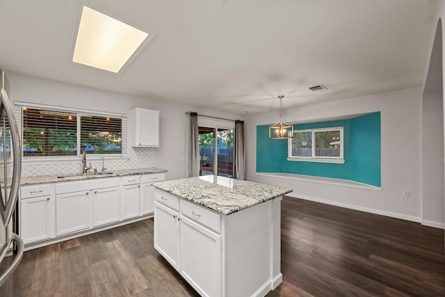 7516 Marble Crest Dr, Austin, TX 78747 - kitchen with a sink, white cabinets, dark wood-style flooring, and a kitchen island