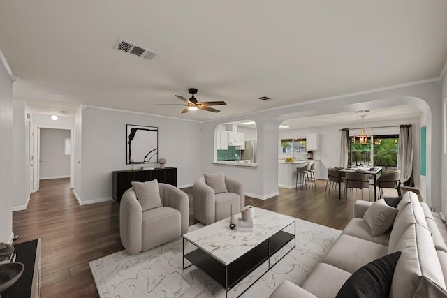 7516 Marble Crest Dr, Austin, TX 78747 - living area featuring arched walkways, wood finished floors, crown molding, ceiling fan, and baseboards