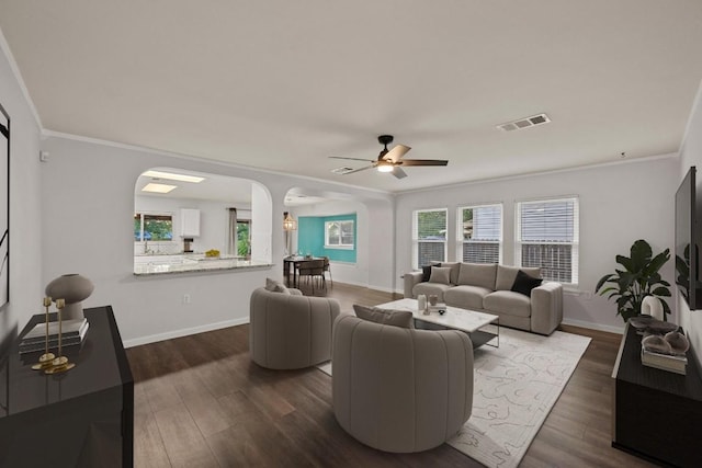 7516 Marble Crest Dr, Austin, TX 78747 - living area featuring arched walkways, crown molding, dark wood-style floors, a ceiling fan, and baseboards