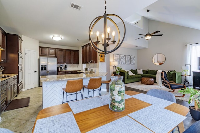 2113 Spring Hollow Path, Round Rock, TX 78681 - dining area featuring a chandelier, ceiling fan, lofted ceiling, and light tile patterned flooring