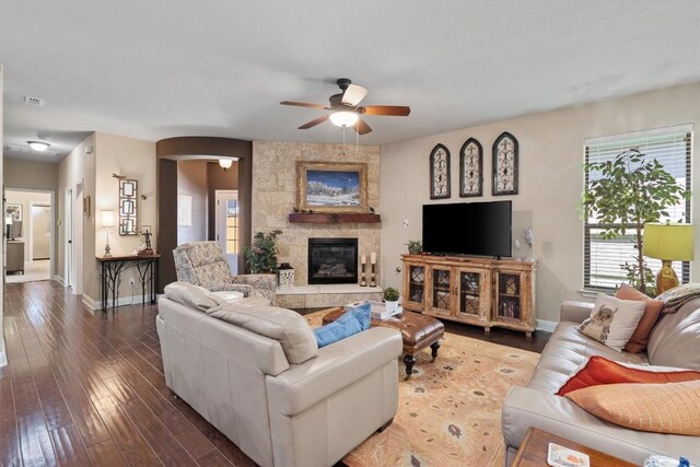 4332 Teravista Club Dr Unit 69, Round Rock, TX 78665 - living room featuring a ceiling fan, arched walkways, baseboards, a stone fireplace, and wood-type flooring