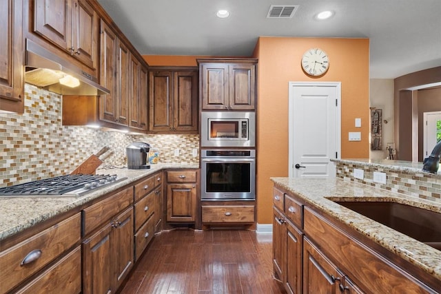 4332 Teravista Club Dr Unit 69, Round Rock, TX 78665 - kitchen featuring stainless steel appliances, under cabinet range hood, a sink, light stone countertops, and tasteful backsplash