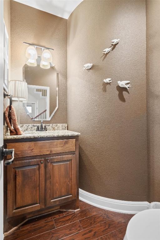 4332 Teravista Club Dr Unit 69, Round Rock, TX 78665 - half bathroom featuring wood finished floors, vanity, a textured wall, and toilet