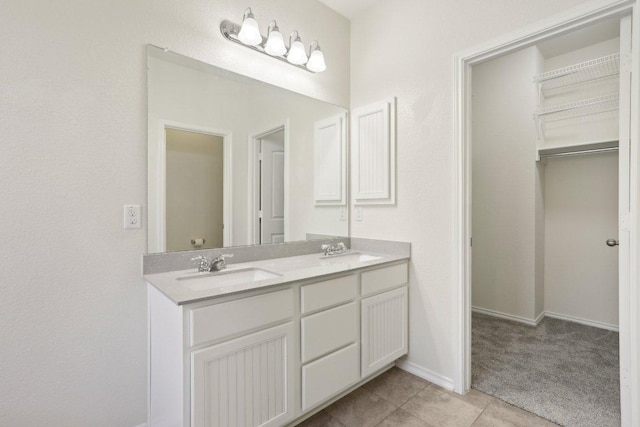 212 Mauldin St, Georgetown, TX 78628 - bathroom featuring double vanity, tile patterned flooring, baseboards, and a walk in closet