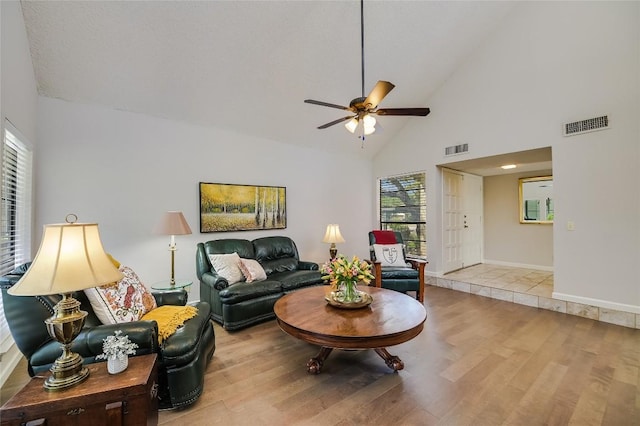 living area with wood finished floors, a ceiling fan, high vaulted ceiling, and baseboards
