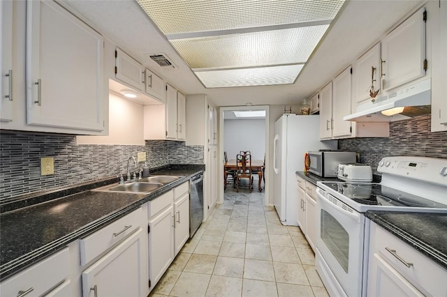 kitchen featuring stainless steel appliances, under cabinet range hood, a sink, and decorative backsplash