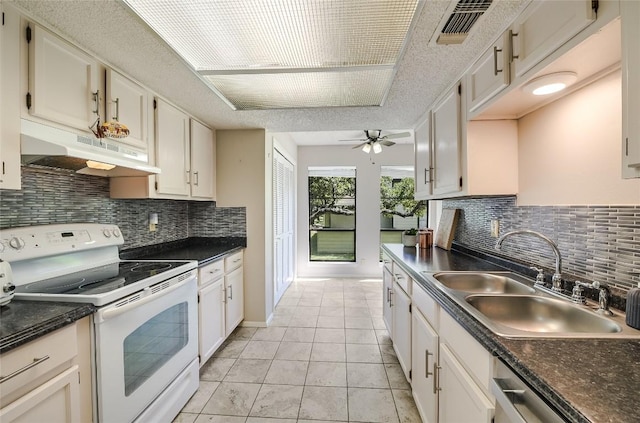 kitchen with under cabinet range hood, electric range, a sink, dark countertops, and ceiling fan