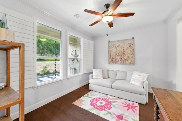 living room with a ceiling fan, ornamental molding, baseboards, and wood finished floors
