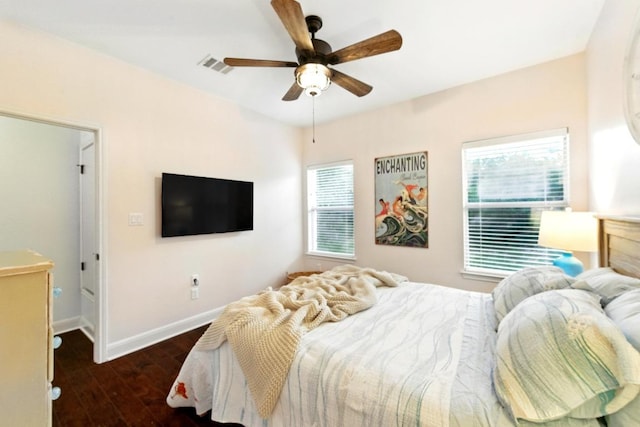 bedroom with multiple windows, baseboards, wood finished floors, and a ceiling fan