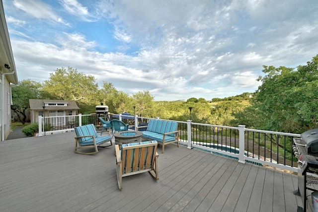 deck with an outdoor fire pit and an outbuilding