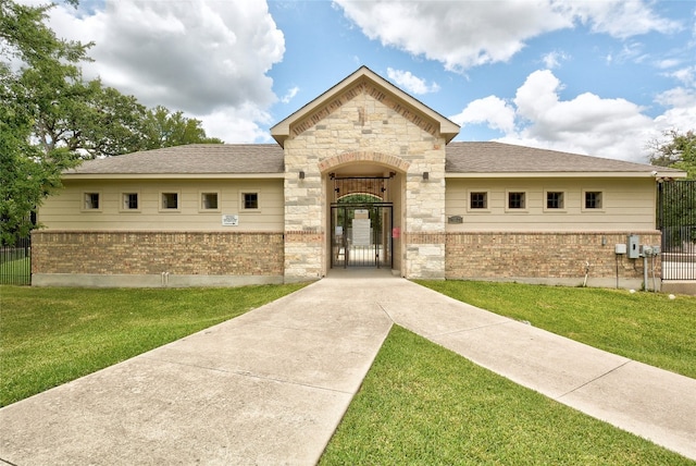 5228 Bantom Woods Bnd, Austin, TX 78724 - french country home featuring a gate, brick siding, stone siding, and roof with shingles